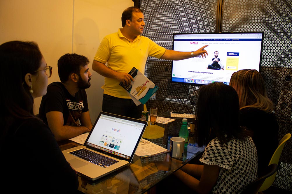 Uma foto da equipe da agência de marketing digital SmMind em reunião representando SEO para ecommerce